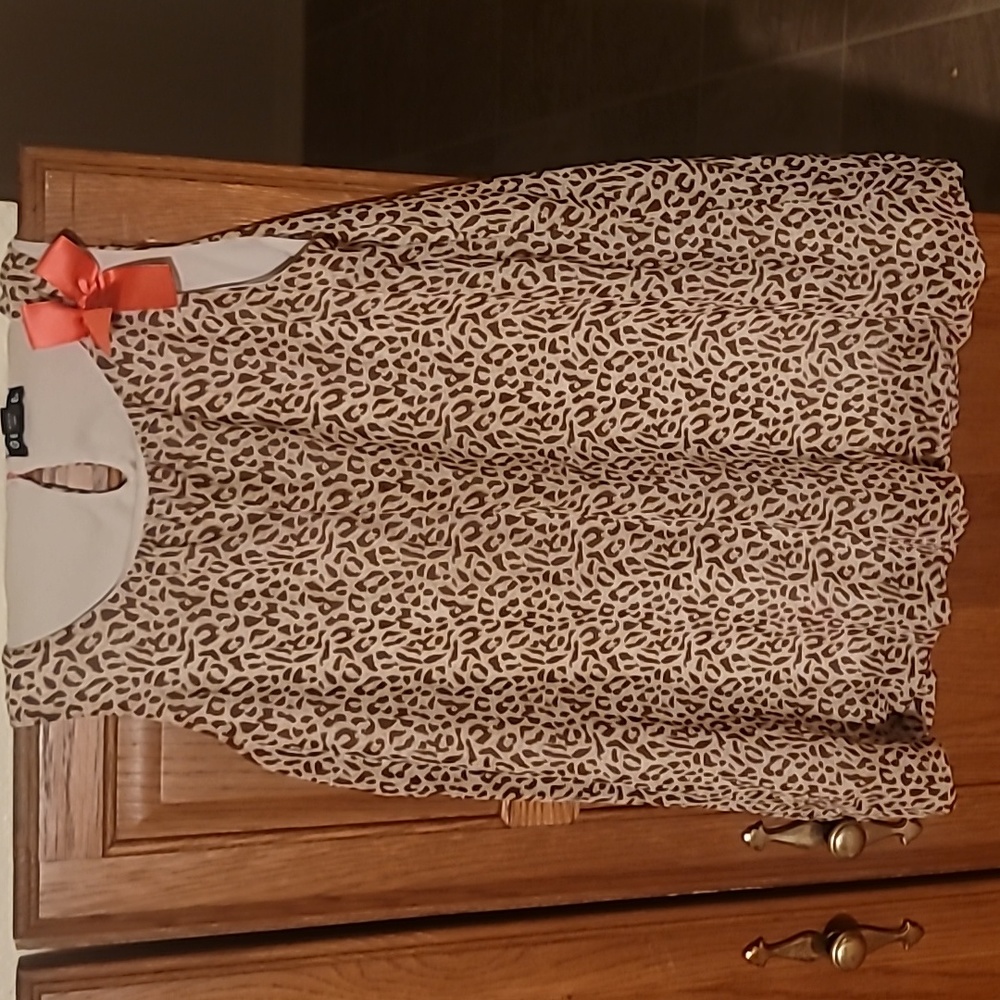 A summer tank top with cheetah pattern with a cute pink bow on the left shoulder